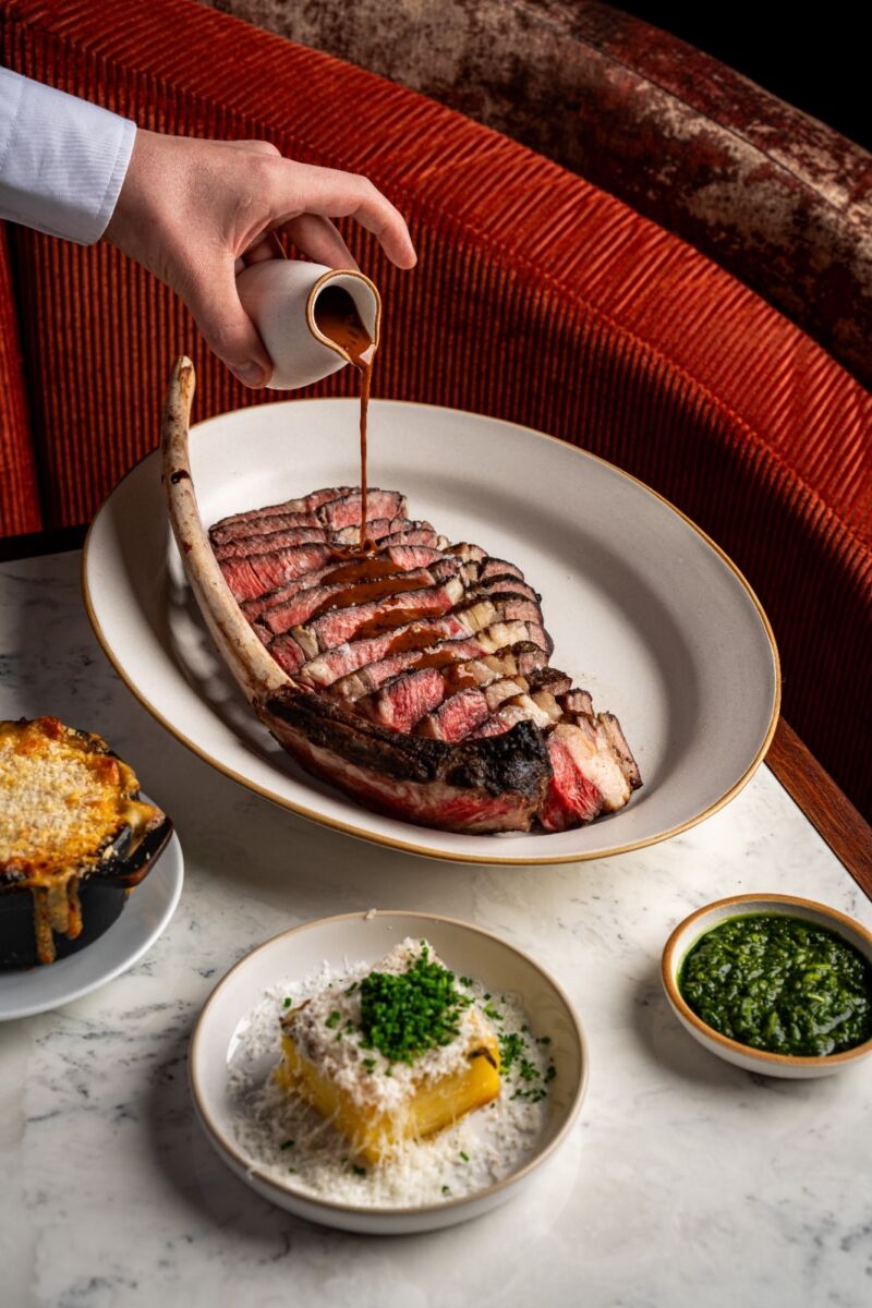 Gravy being poured on a steak