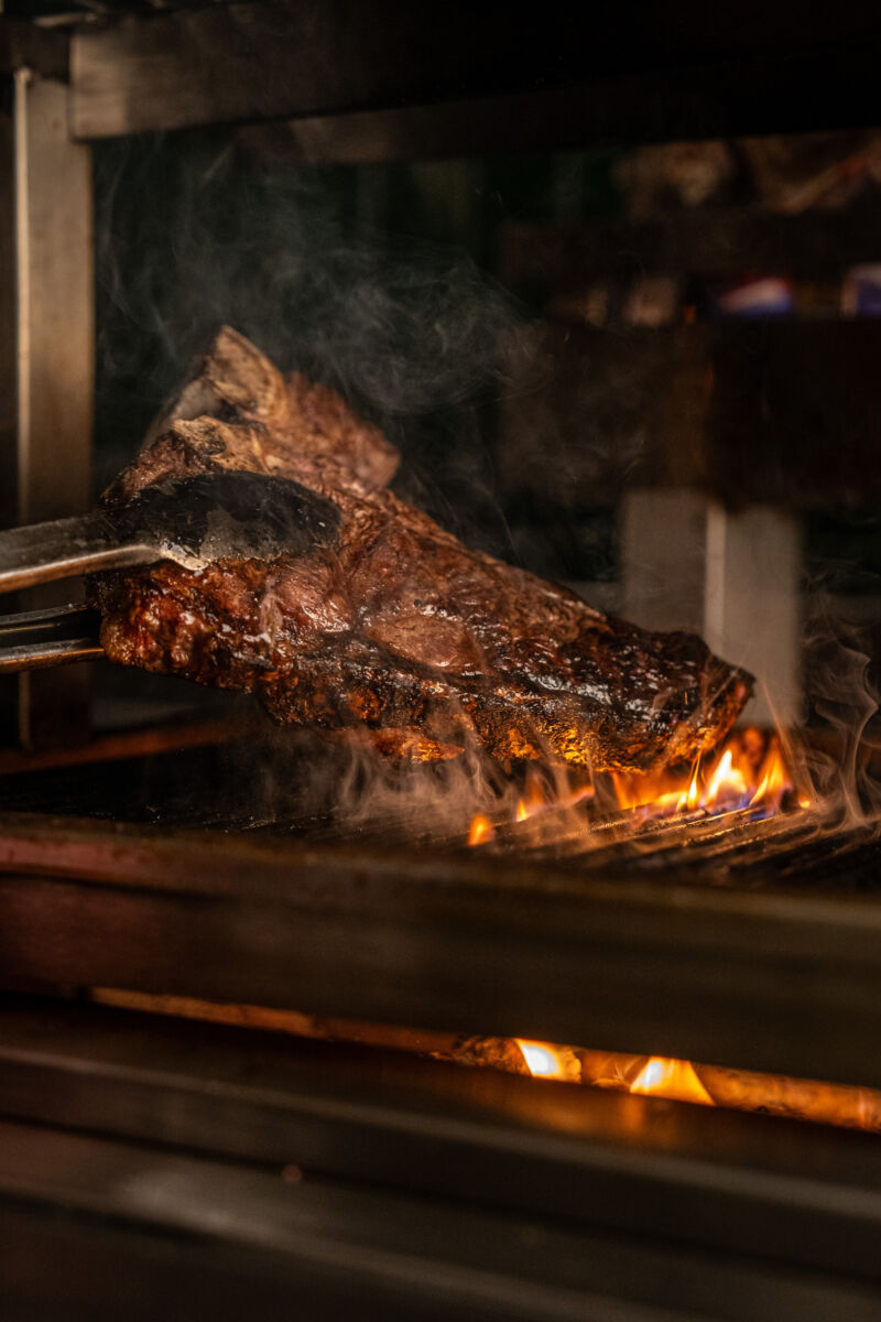 A Steak Cooking On A Coal Fire